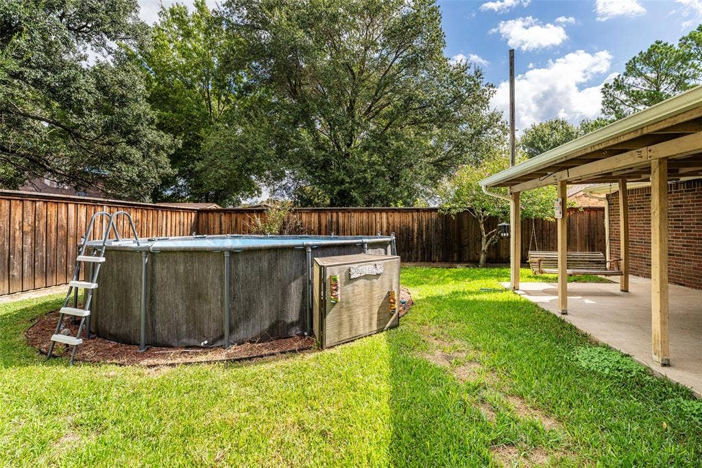 826 Camino Court, Grand Prairie, TX 75052 Backyard featuring a covered patio, brick exterior, above-ground pool, and wood privacy fencing