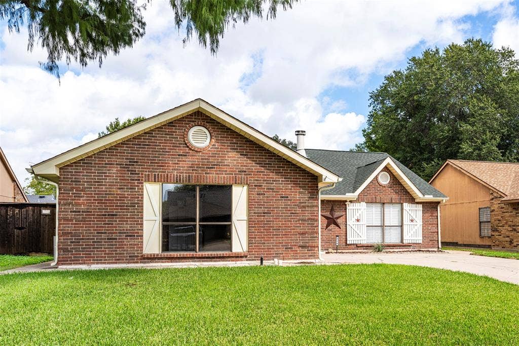 826 Camino Court, Grand Prairie, TX 75052 Single-story brick exterior featuring a gable roof, decorative circular attic vents, and custom window shutters