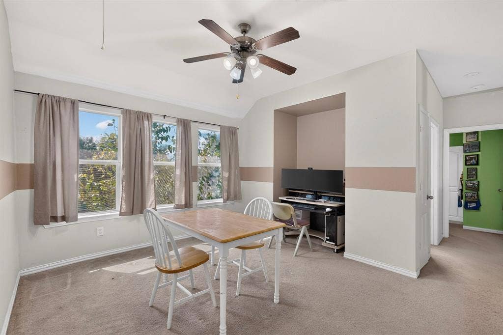 Room featuring a dedicated recessed wall niche, triple-pane window configuration, and a ceiling-mounted light fixture with a multi-blade fan
