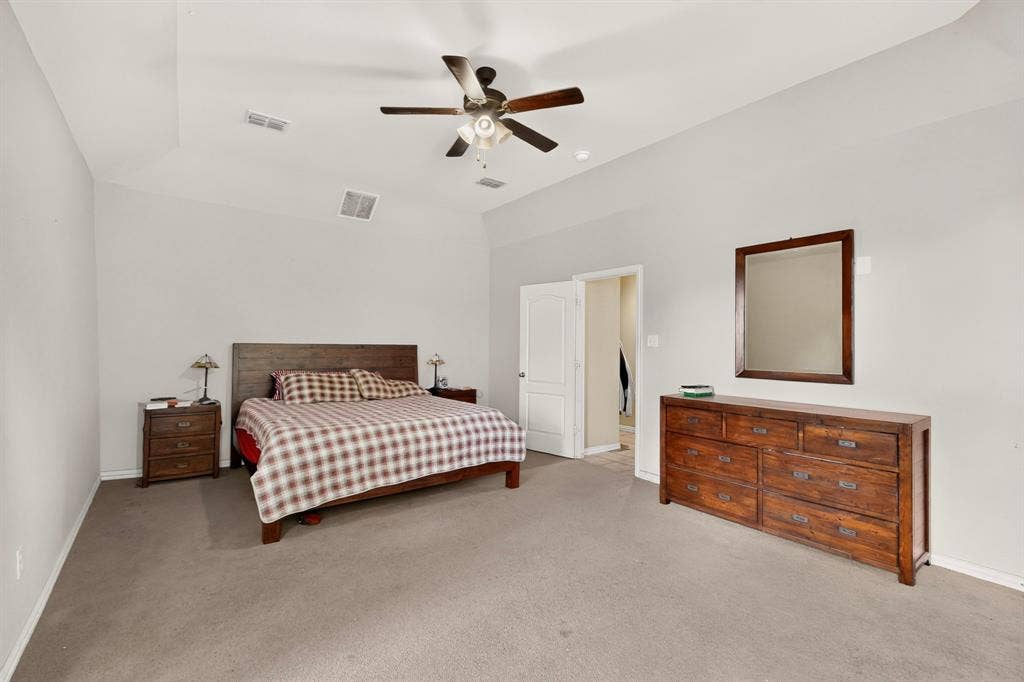 Tray ceiling featuring a central ceiling fan with integrated light fixture and neutral wall finishes