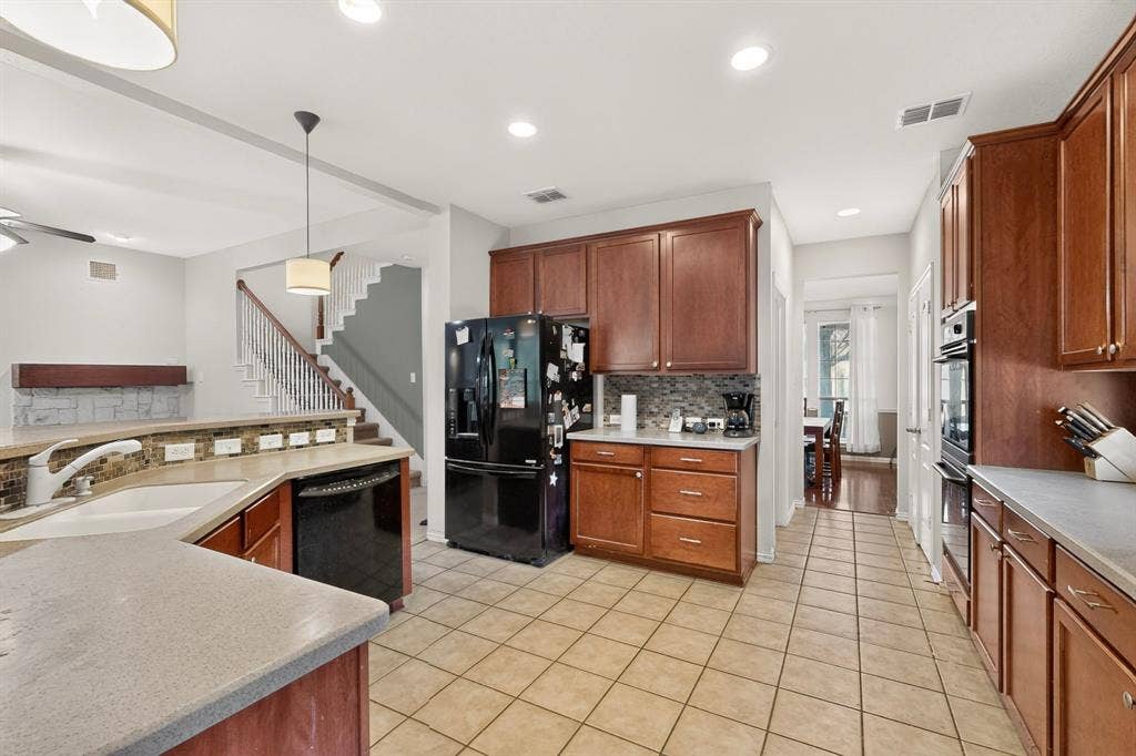 Kitchen featuring stained wood cabinetry, stone-tile backsplash, tile flooring, built-in double wall oven, and recessed lighting