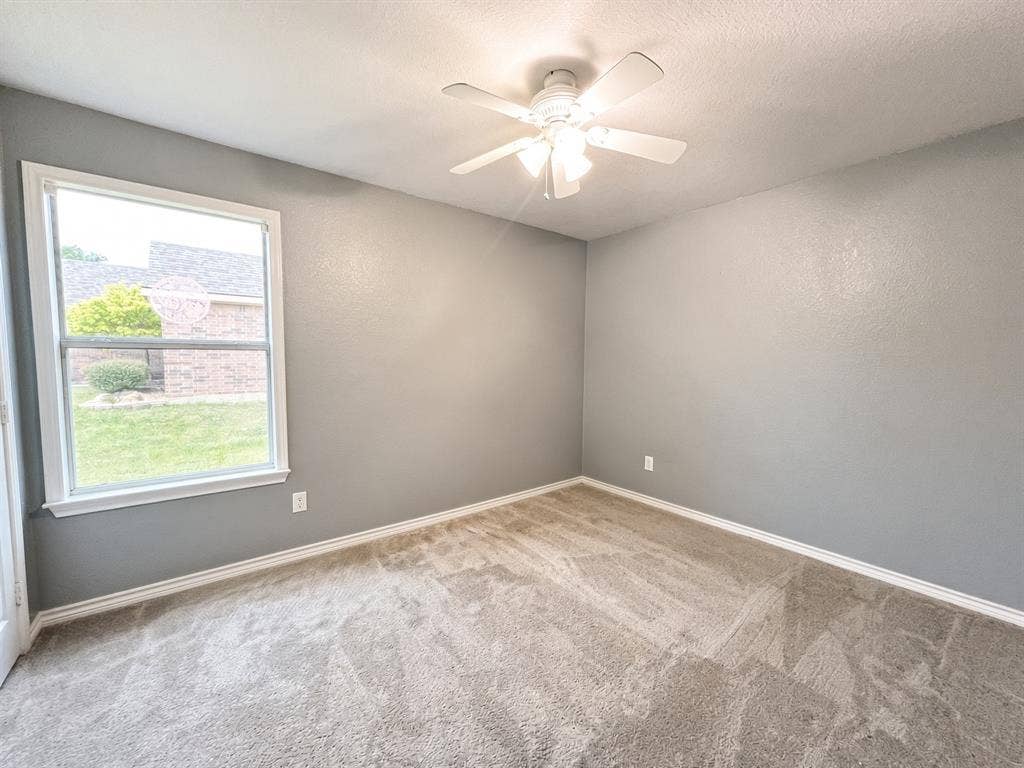 Room featuring neutral wall paint, wall-to-wall carpeting, a multi-light ceiling fan, and a single-pane window