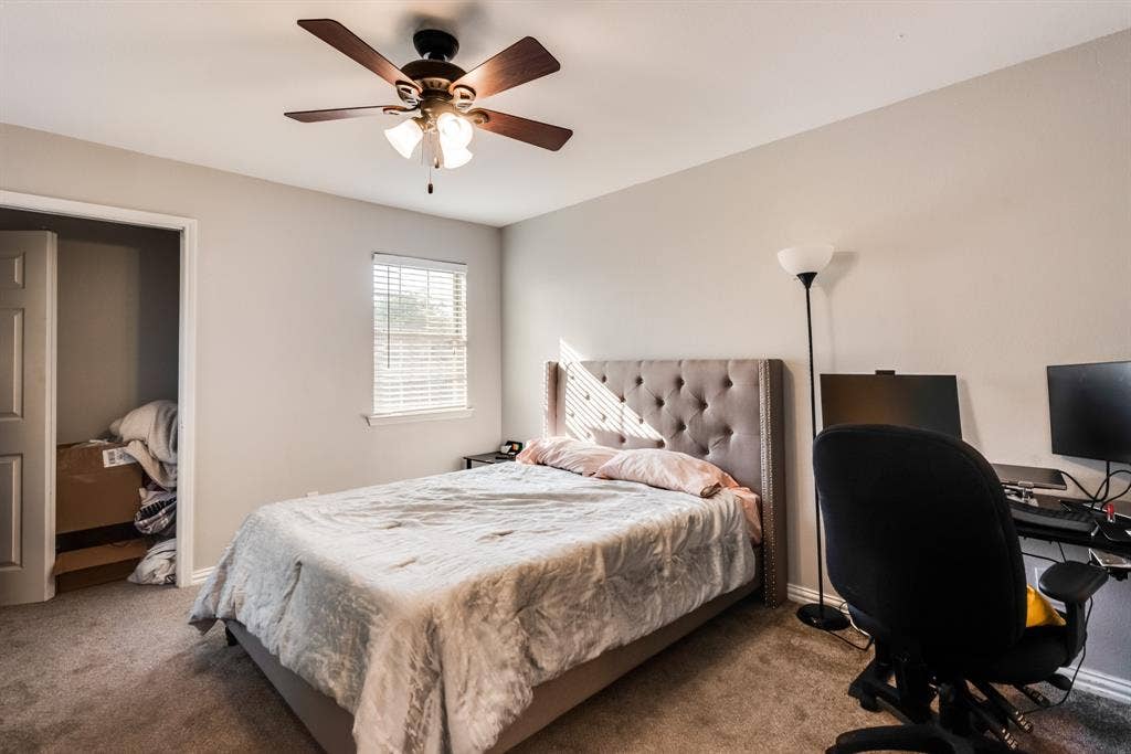 Secondary bedroom with a celling fan and private closet.