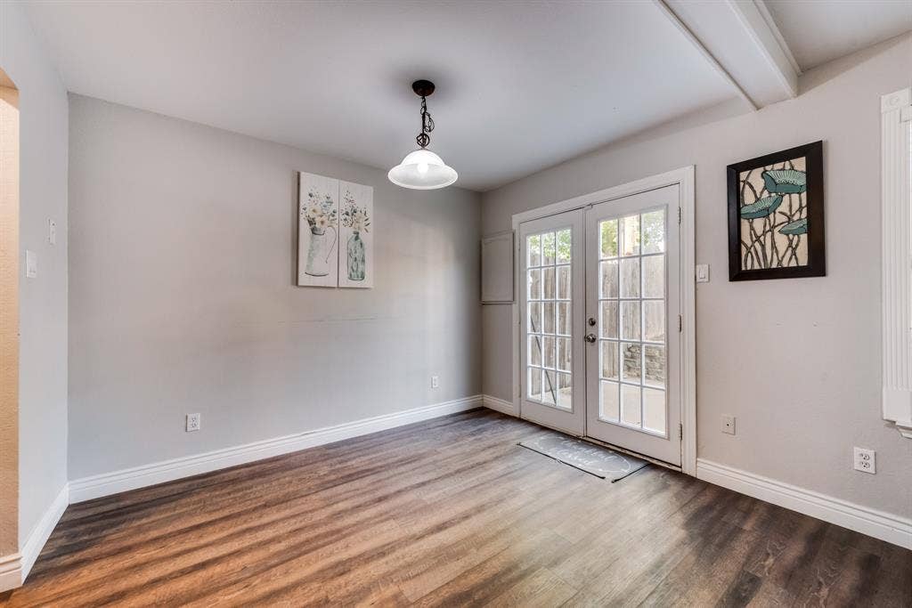 Well lit dining area with natural lighting and double doors leading to the backyard.