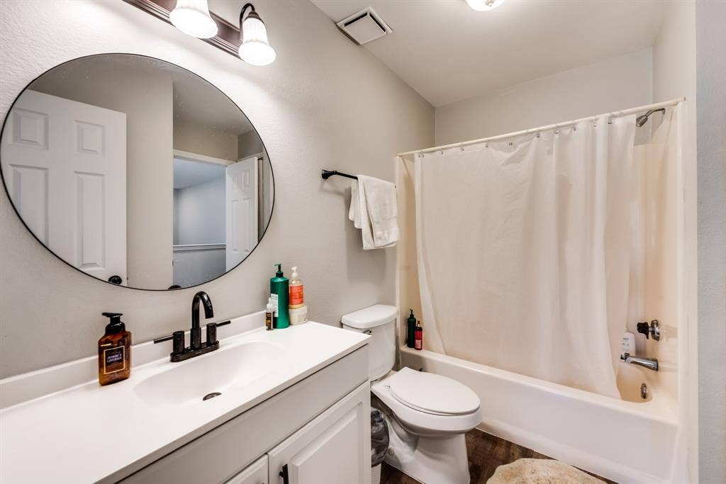 Second bathroom with a vanity and bath / shower combo.