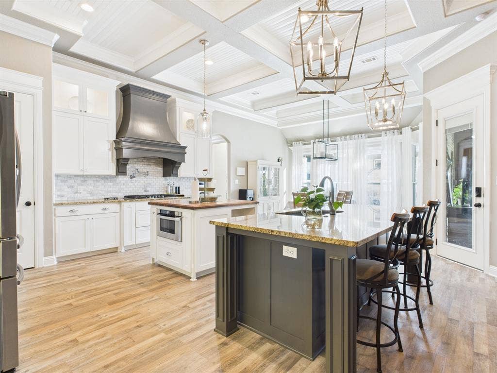 1201 E Iberian Court, Granbury, TX 76048 Gourmet kitchen featuring a coffered ceiling, dual center islands, custom cabinetry, a metal range hood, and wood-finish flooring