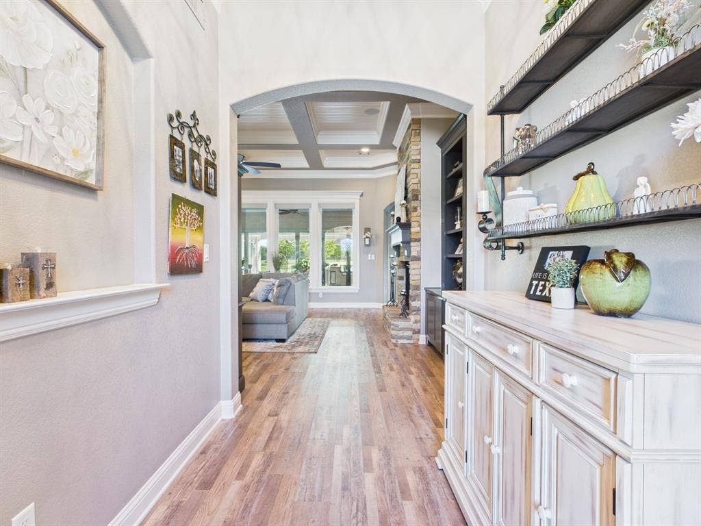 1201 E Iberian Court, Granbury, TX 76048 Entryway featuring wood-finish flooring, an arched entryway, a recessed wall niche, and coffered ceilings