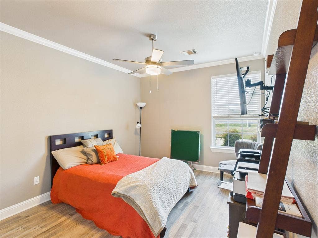 1201 E Iberian Court, Granbury, TX 76048 Wood-finish flooring, ceiling fan with integrated lighting, crown molding, and a window with horizontal blinds