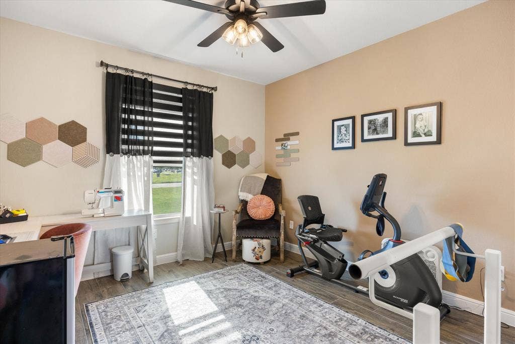 Wood-finish flooring, multi-light ceiling fan, and window featuring horizontal blinds