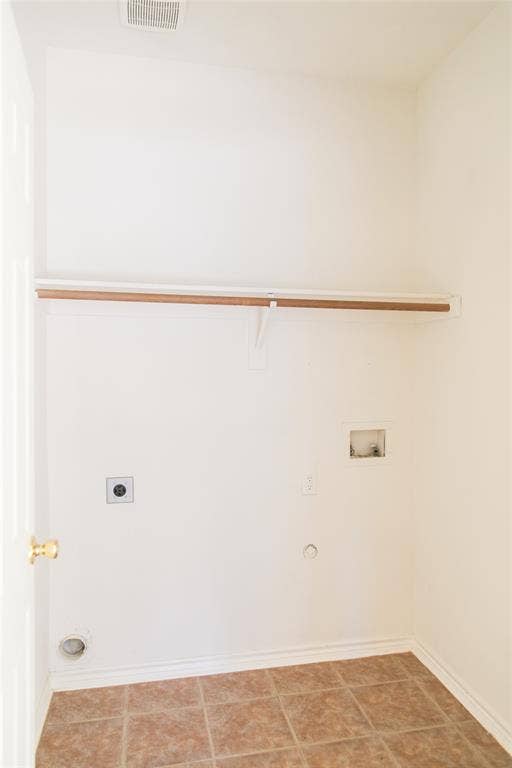 404 Belmont Court, Lewisville, TX 75067 Utility space featuring tile flooring, a wall-mounted shelf, and a built-in hanging rod