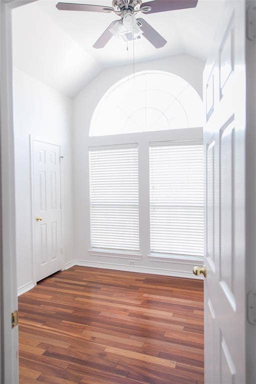 404 Belmont Court, Lewisville, TX 75067 Vaulted ceilings featuring an arched window, wood-finish flooring, and a ceiling-mounted fan with integrated lighting