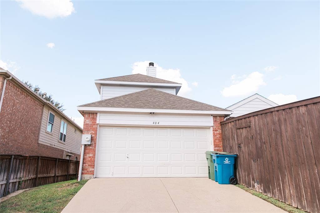 404 Belmont Court, Lewisville, TX 75067 Two-story exterior featuring a brick and horizontal siding facade, shingle roof, chimney stack, and a two-car garage