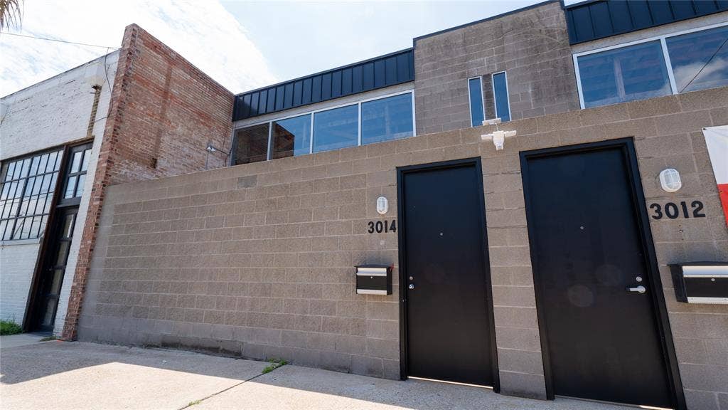 3012 Canton Street, Dallas, TX 75226 Industrial exterior featuring masonry walls, large-format glass window panels, flat roofing, and modern metal entry doors