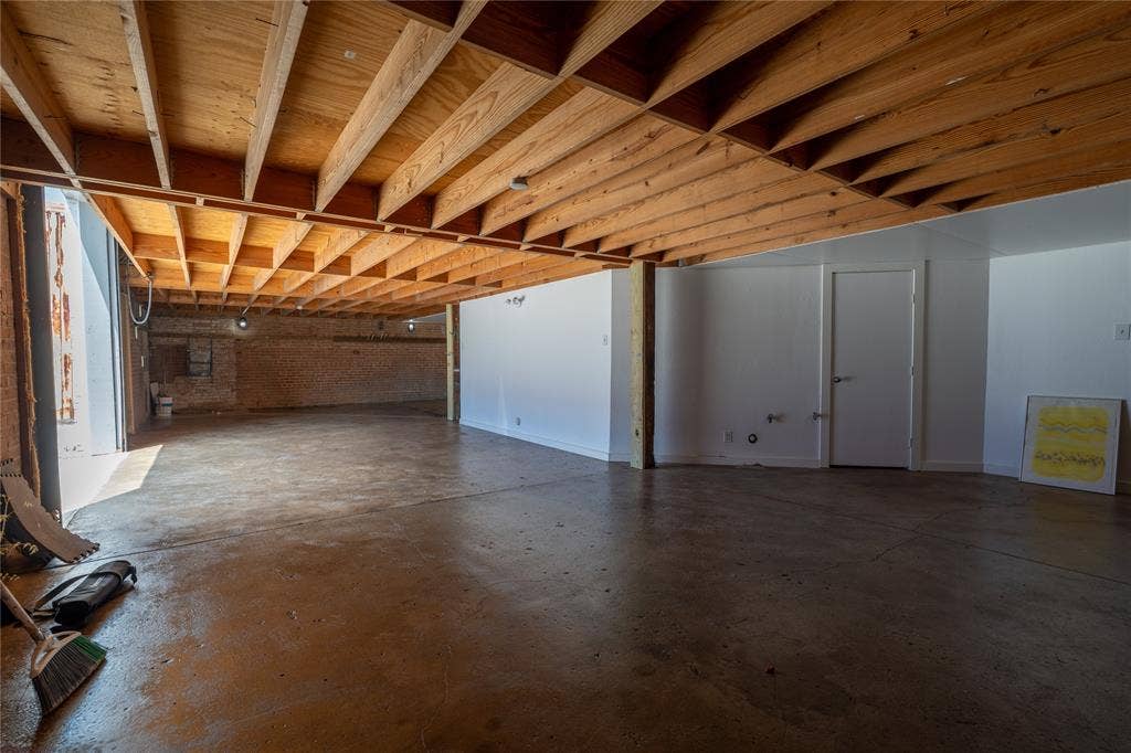 3012 Canton Street, Dallas, TX 75226 Expansive lower level featuring exposed wood joist ceilings, polished concrete flooring, white walls, and a structural timber support column