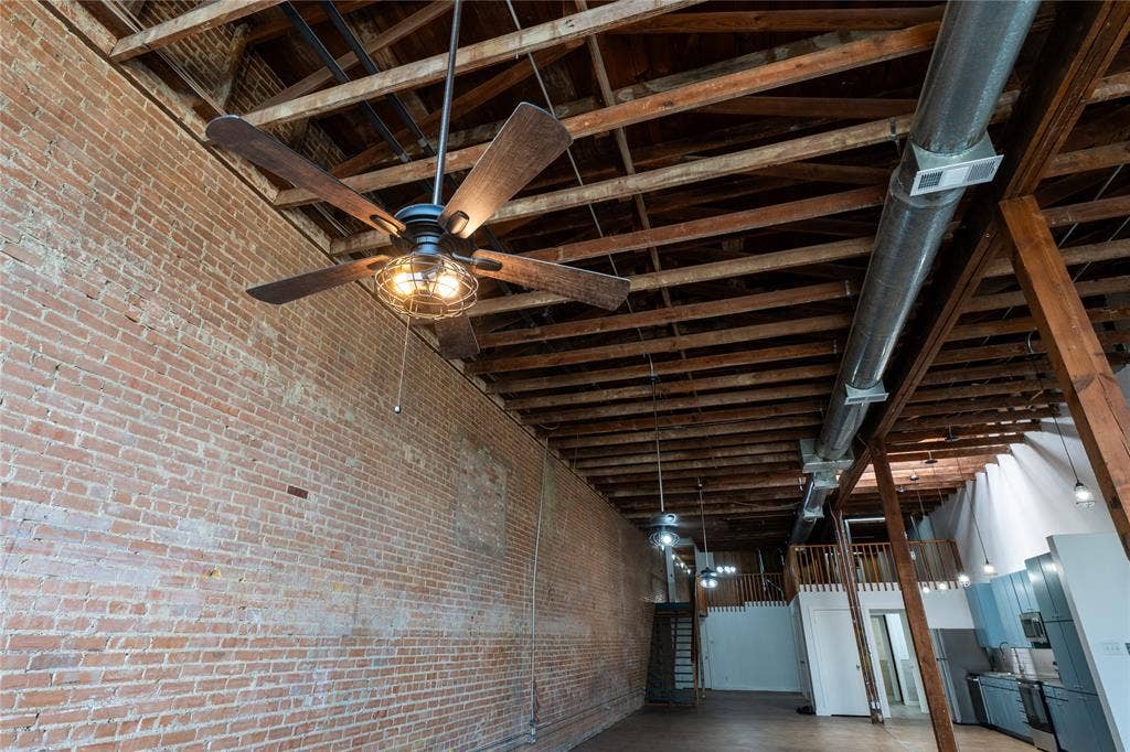3012 Canton Street, Dallas, TX 75226 Industrial interior featuring exposed brick walls, vaulted timber-beam ceilings, exposed ductwork, and suspended cage-style ceiling fans