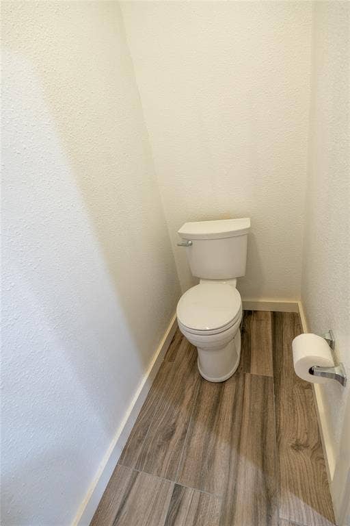 3012 Canton Street, Dallas, TX 75226 Standard-height porcelain toilet paired with wood-finish flooring and a chrome toilet paper holder