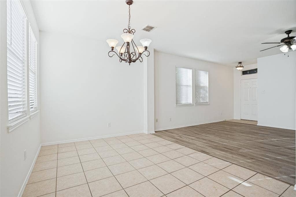 1507 Bankston Drive, Wylie, TX 75098 Open-concept interior featuring wood-finish flooring, neutral tile flooring, a multi-arm chandelier, and white blinds on dual-pane windows