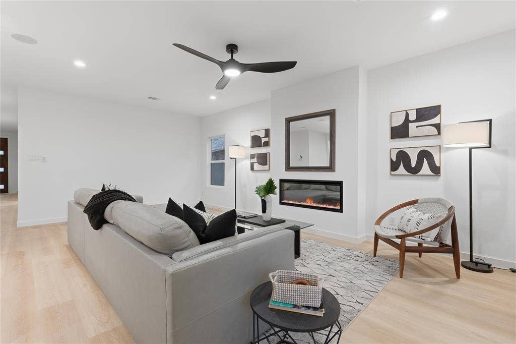 Living area featuring wood-finish flooring, a linear fireplace, recessed lighting, and a modern ceiling fan