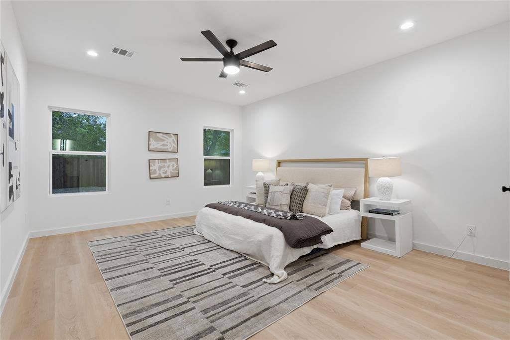 Light-filled room featuring wood-finish flooring, recessed lighting, and a modern ceiling fan with integrated light fixture