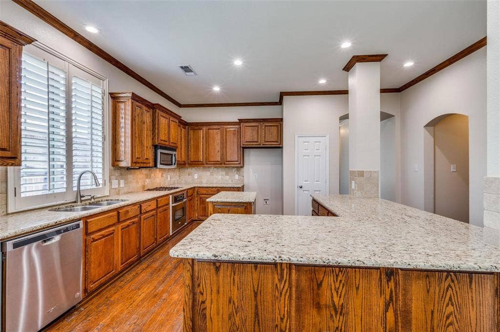 1441 Kirkwood Lane, Prosper, TX 75078 Kitchen featuring wood cabinetry, stone countertops, stainless steel dishwasher, wood-finish flooring, and recessed ceiling lighting
