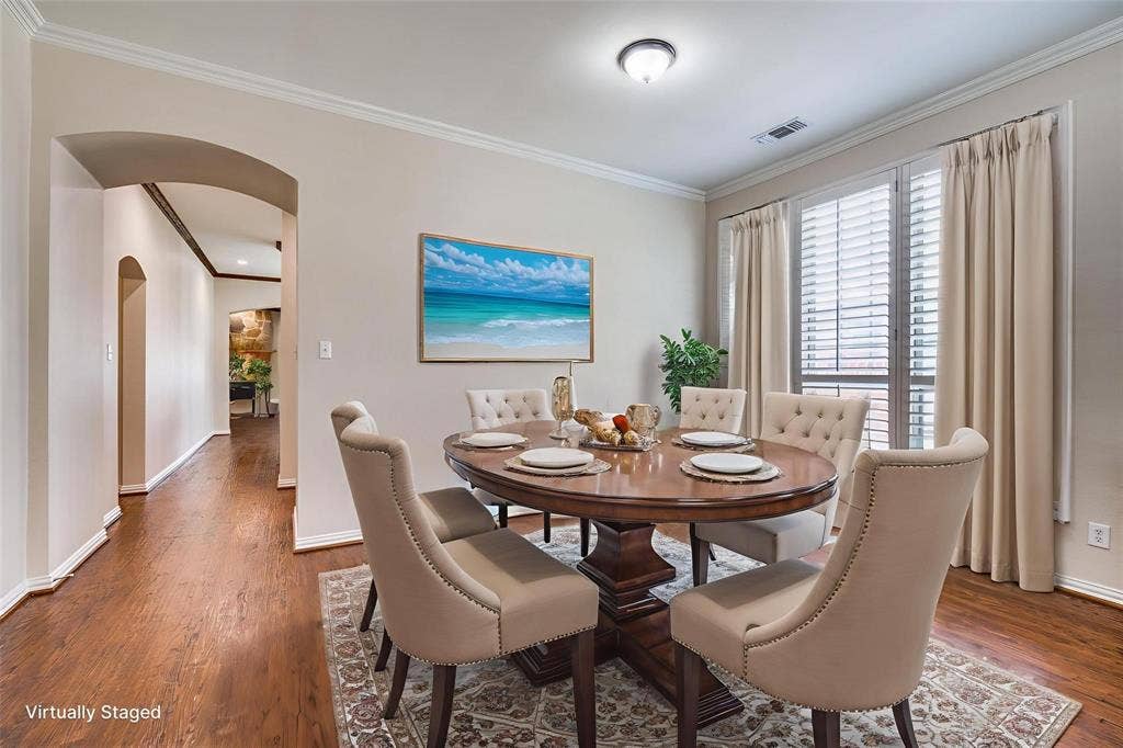 1441 Kirkwood Lane, Prosper, TX 75078 Dining area featuring wood-finish flooring, crown molding, arched entryways, and floor-to-ceiling windows with horizontal blinds