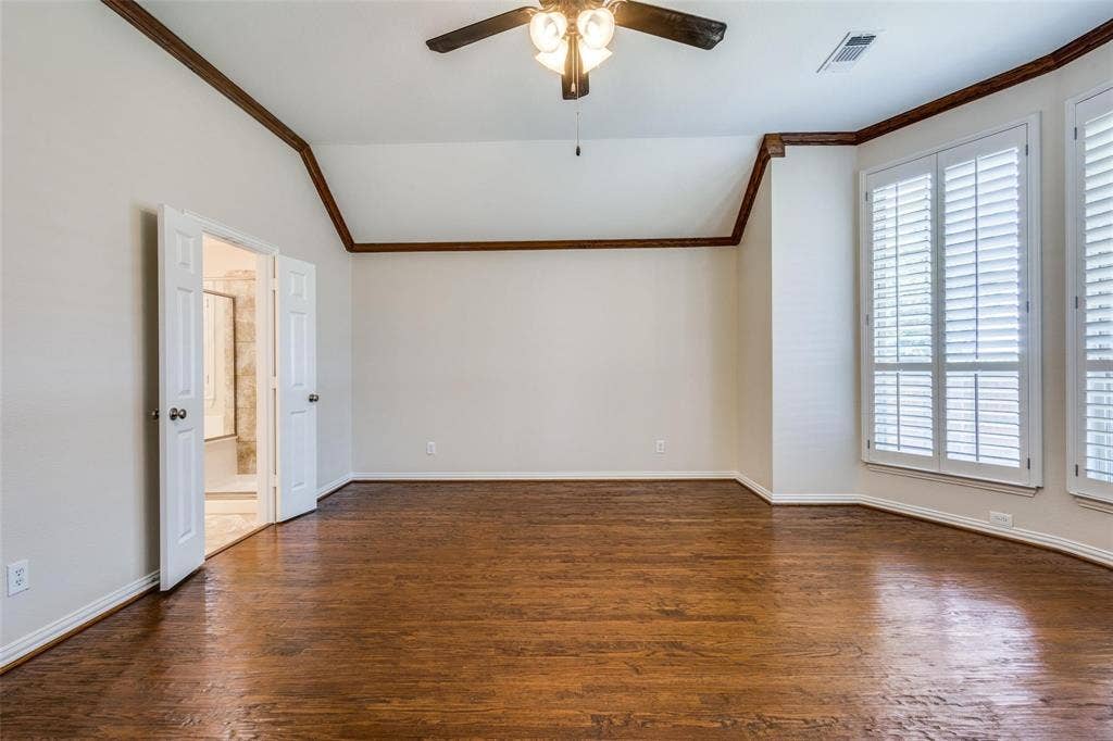 1441 Kirkwood Lane, Prosper, TX 75078 Vaulted ceiling with crown molding, wood-finish flooring, plantation shutters, and a ceiling-mounted light fixture with a fan