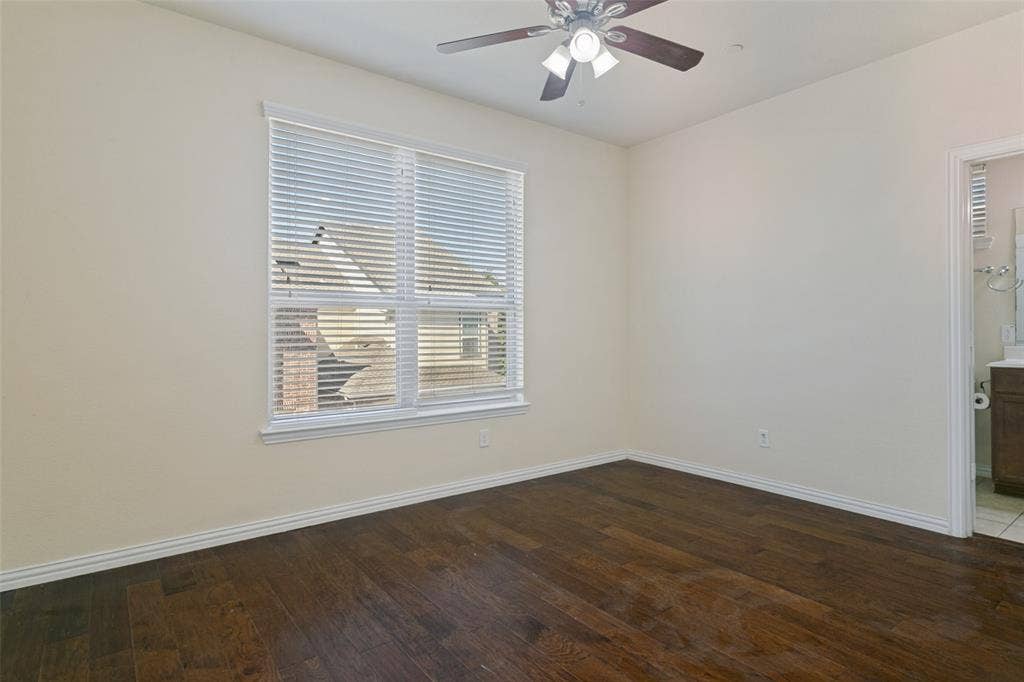 Room featuring wood-finish flooring, a ceiling fan with integrated lighting, and a window with horizontal blinds
