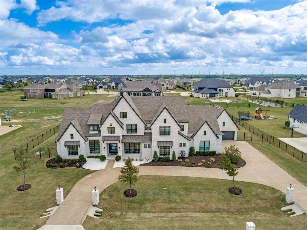 4604 Devon Drive, Parker, TX 75002 Multi-gabled exterior featuring light brick masonry, metal roof accents, multi-pane windows, a sprawling front lawn, and a wide concrete circular driveway