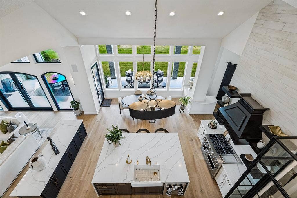 4604 Devon Drive, Parker, TX 75002 Vaulted ceilings, expansive windows, large center island with integrated apron-front sink, stone-finish kitchen hood, and light-tone wood-finish flooring