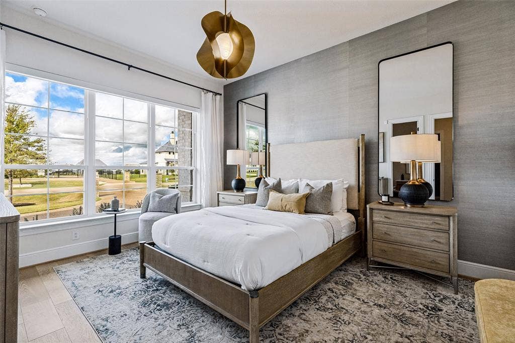 4604 Devon Drive, Parker, TX 75002 Bedroom featuring wood-finish flooring, a textural gray accent wall, expansive multi-pane windows, and a sculptural gold-tone pendant light fixture