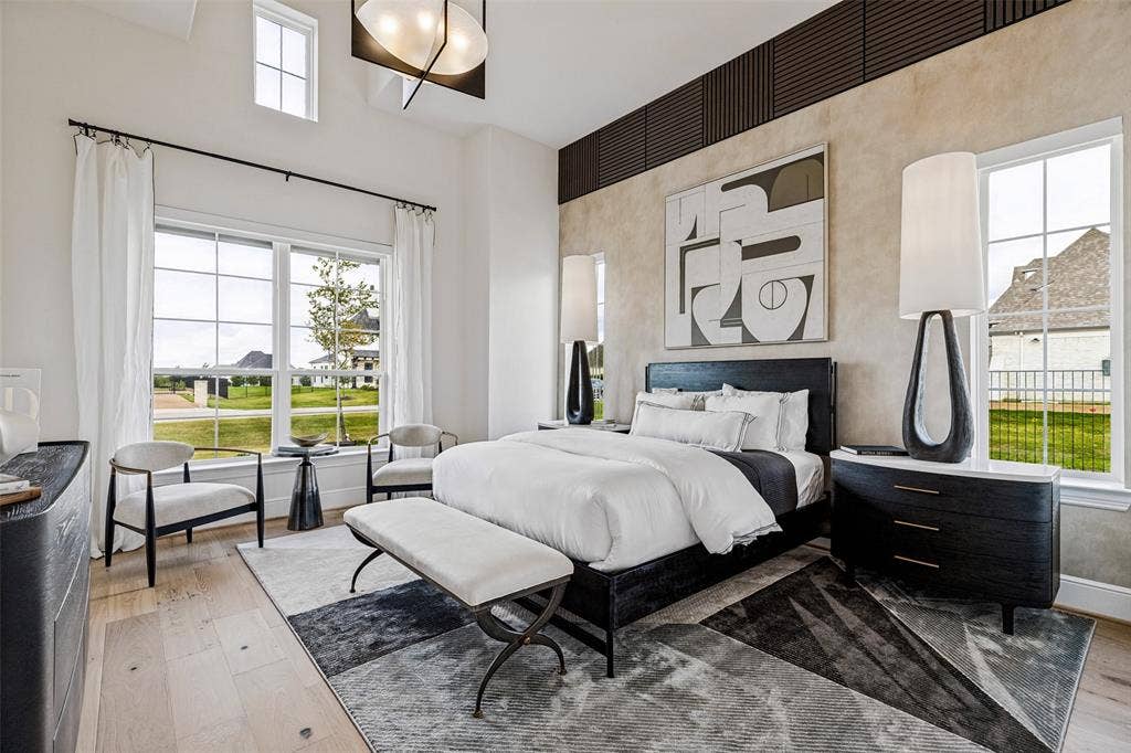 4604 Devon Drive, Parker, TX 75002 High-ceiling room featuring wood-finish flooring, multi-pane windows, a geometric accent wall treatment, and a modern tiered chandelier