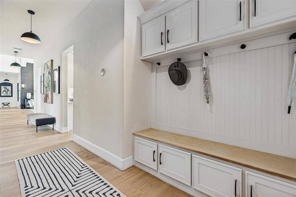 4604 Devon Drive, Parker, TX 75002 Built-in white cabinetry featuring beadboard paneling, upper storage lockers, lower base cabinets, a wood-finish bench seat, and matte black hardware