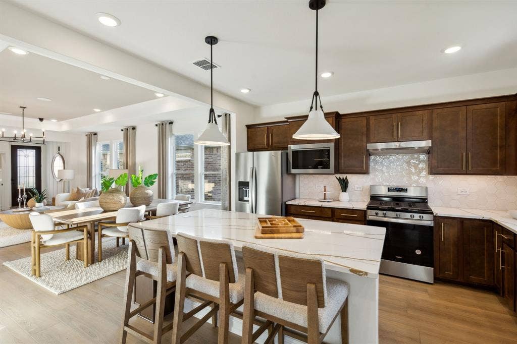 304 Snowbird Way, McKinney, TX 75071 *Model Representation - Large island gathering room and dining areas overlooking