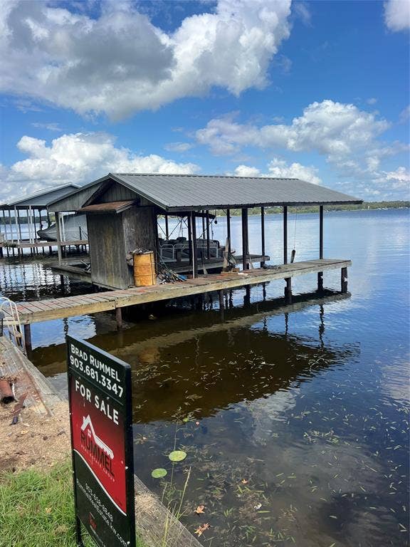 3723 County Road 4806, Athens, TX 75752 Covered boat slip featuring a metal roof and wood-plank decking