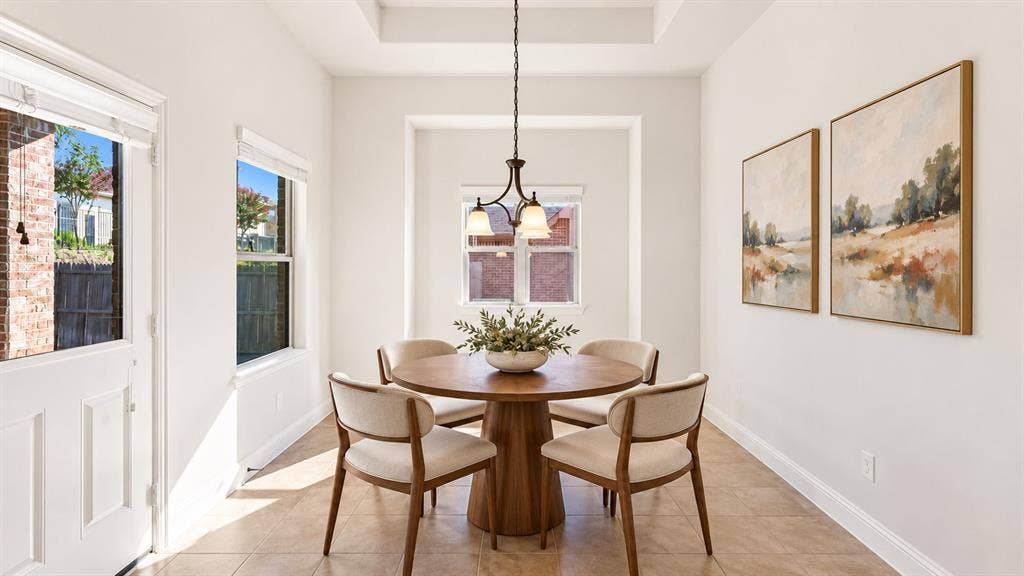 632 Grisham Drive, Fate, TX 75087 Tray ceiling, three-light metal pendant fixture, tile flooring, and multiple windows with integrated blinds
