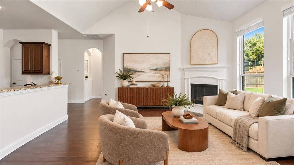 632 Grisham Drive, Fate, TX 75087 Vaulted ceiling, wood-finish flooring, fireplace with a decorative mantel, and multi-paned windows