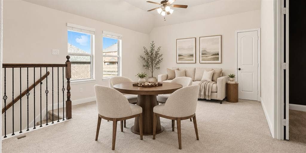 632 Grisham Drive, Fate, TX 75087 Vaulted ceiling with an integrated light-and-fan fixture, carpeted flooring, two paneled windows, and a black wrought-iron stair railing with a wooden newel post