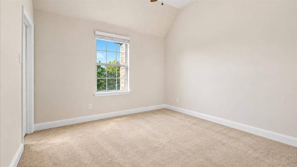 632 Grisham Drive, Fate, TX 75087 Vaulted ceiling, wall-to-wall carpeting, and a grid-pattern window with exterior brick detail
