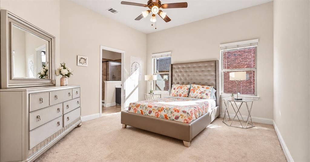 632 Grisham Drive, Fate, TX 75087 High-ceiling bedroom featuring neutral carpeting, a central multi-light ceiling fan, and two windows with blinds