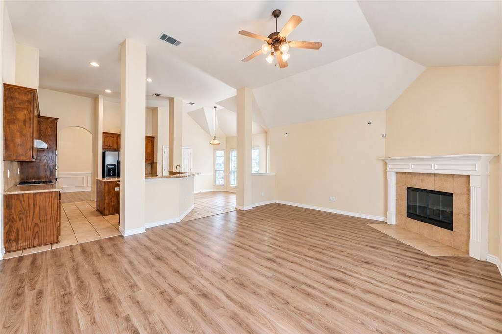 1736 Blue Stream Drive, DeSoto, TX 75115 Vaulted ceilings, wood-look LVP flooring, fireplace with a mantle, recessed lighting, and kitchen cabinetry