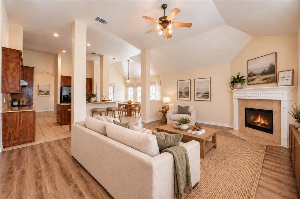 1736 Blue Stream Drive, DeSoto, TX 75115 Vaulted ceilings, fireplace with custom mantle, wood-look LVP flooring, recessed lighting, and kitchen with cabinetry and counter seating *Virtually staged to show potential*