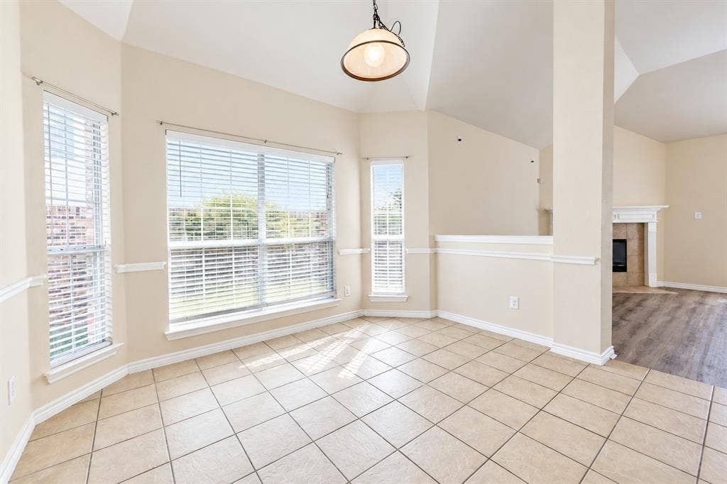 1736 Blue Stream Drive, DeSoto, TX 75115 Vaulted ceilings, large windows with horizontal blinds, neutral tile flooring, chair rail molding, and a dome-style pendant light fixture