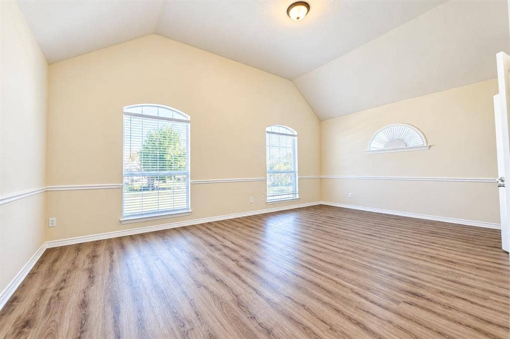 1736 Blue Stream Drive, DeSoto, TX 75115 Vaulted ceilings, wood-look LVP flooring, chair rail molding, and arched windows with integrated blinds
