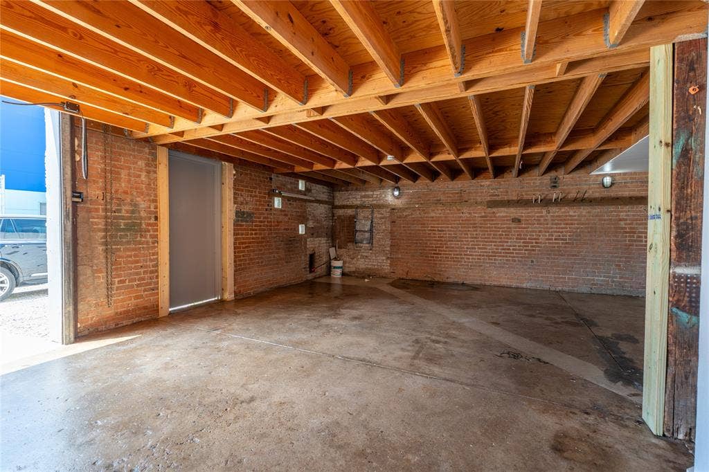 3014 Canton Street, Dallas, TX 75226 Exposed brick walls, open wood-beam ceiling, and concrete flooring