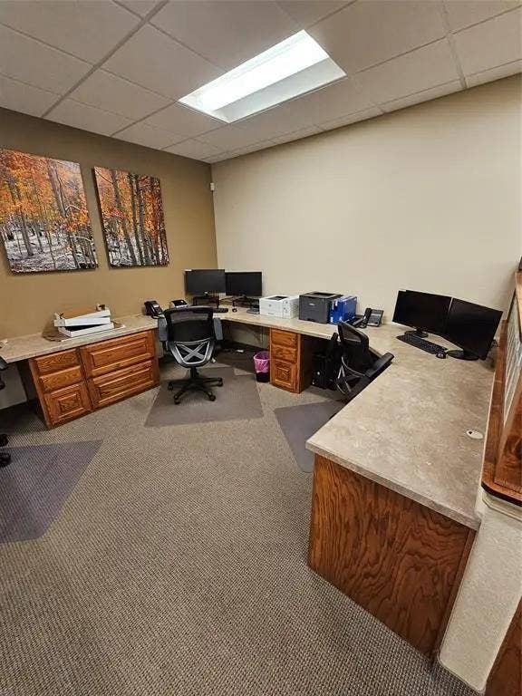 1831 W Louisiana Street, McKinney, TX 75069 Built-in wood-finish cabinetry featuring extensive desk workspace, integrated solid-surface countertops, recessed ceiling lighting, and carpeted flooring
