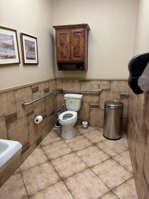 1831 W Louisiana Street, McKinney, TX 75069 Restroom featuring tile flooring, stone-finish wall tile, metal grab bars, and dark wood-finish cabinetry