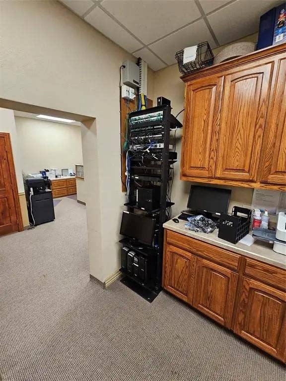 1831 W Louisiana Street, McKinney, TX 75069 Wall-mounted wooden cabinetry with upper and lower storage, laminate countertop, and dedicated server rack