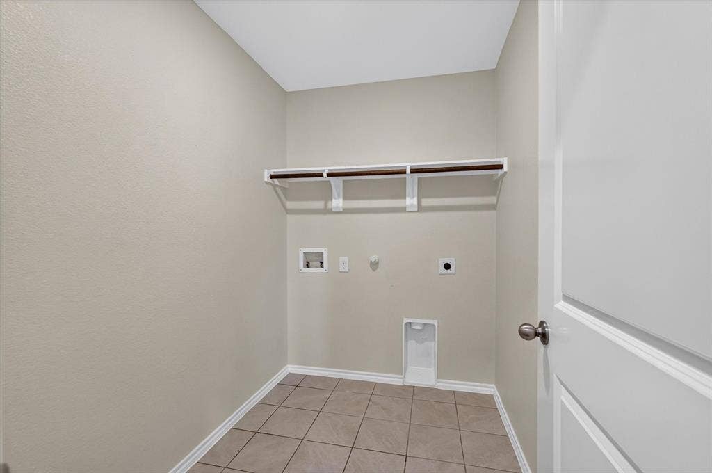 114 Real Quiet Lane, Caddo Mills, TX 75135 Utility space featuring ceramic tile flooring, built-in shelving with integrated garment rod, and wall-mounted utility connections
