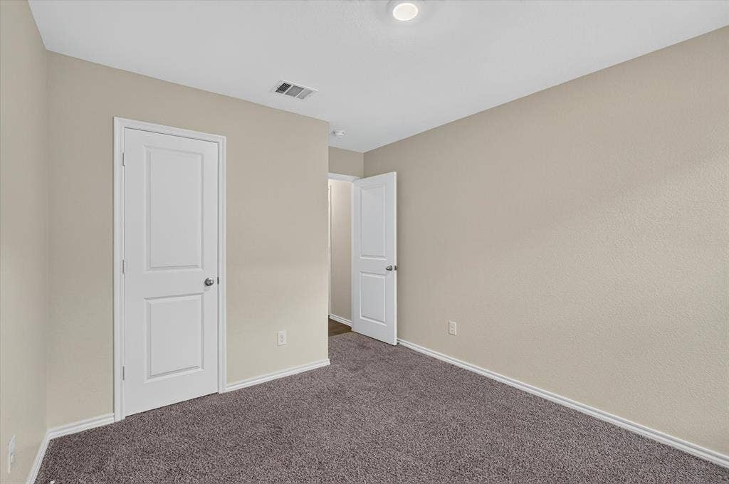 114 Real Quiet Lane, Caddo Mills, TX 75135 Neutral interior space featuring textured wall finishes, wall-to-wall carpeting, and two-panel doors with metallic hardware