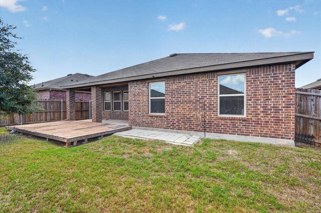 114 Real Quiet Lane, Caddo Mills, TX 75135 Brick exterior, rear wood deck, paved patio, and wood privacy fencing